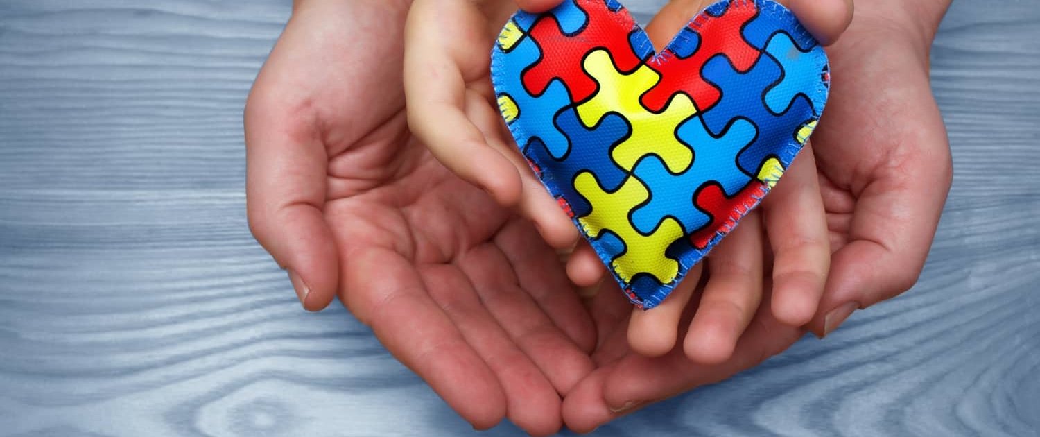 Heart puzzle symbol of autism in human hands