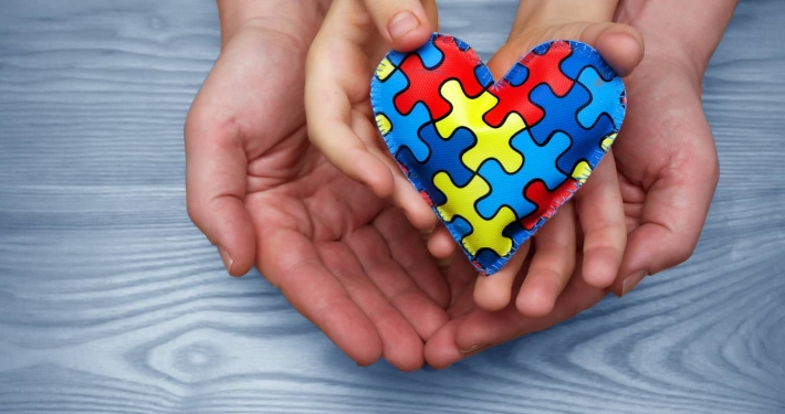 Heart puzzle symbol of autism in human hands