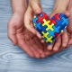 Heart puzzle symbol of autism in human hands