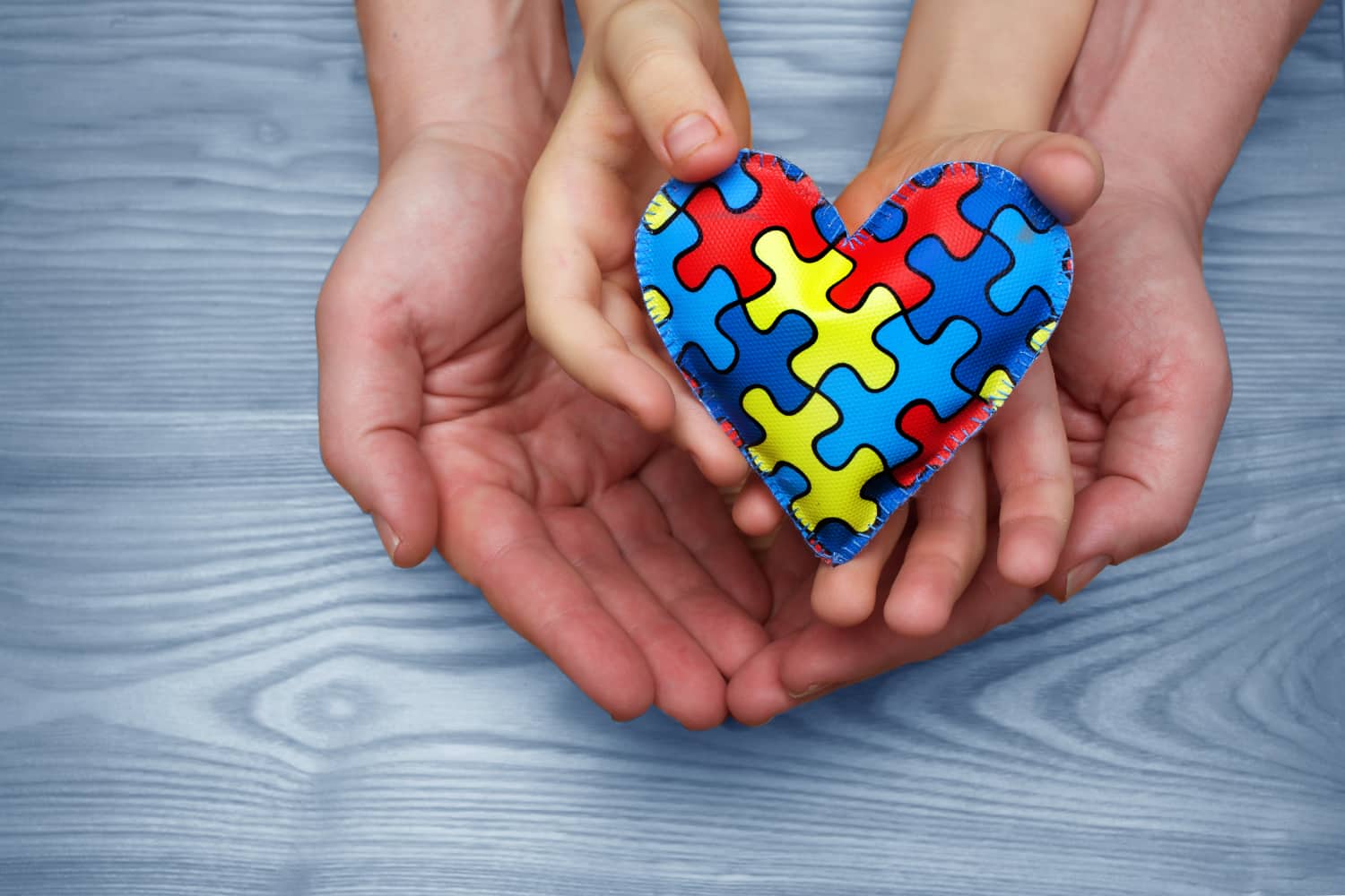 Heart puzzle symbol of autism in human hands