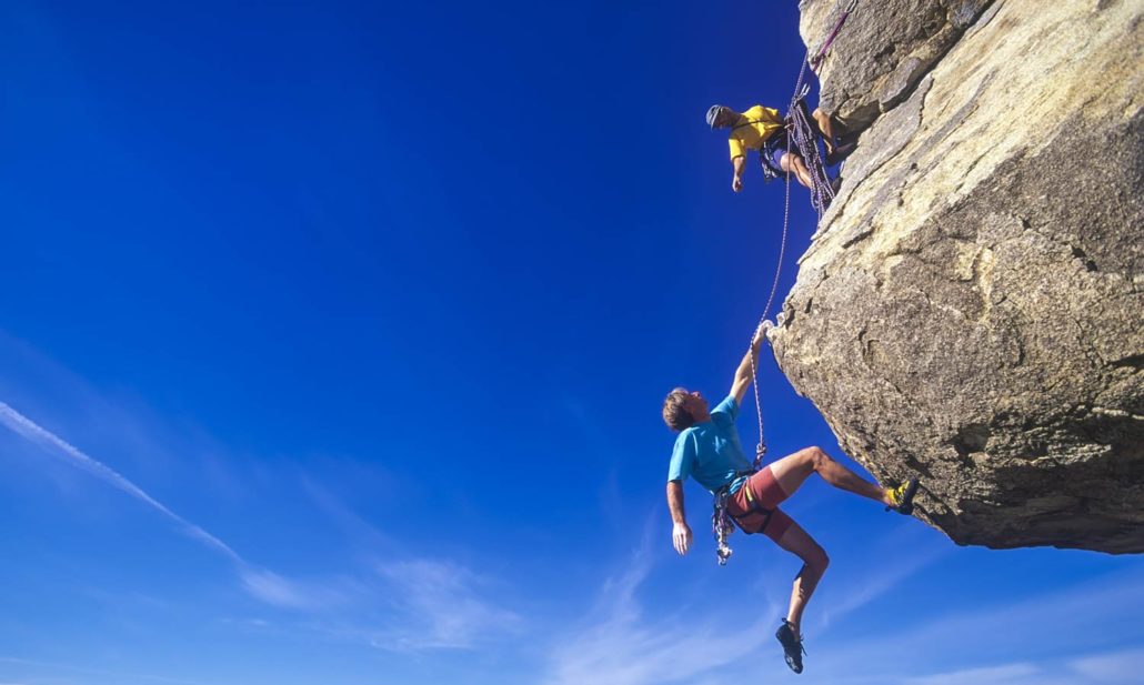 Two rock climbers scale a challenging peak