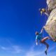Two rock climbers scale a challenging peak