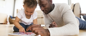A parent and his toddler explore a digital tablet
