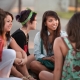 A group of teen girls sit talking with each other in a supportive manner